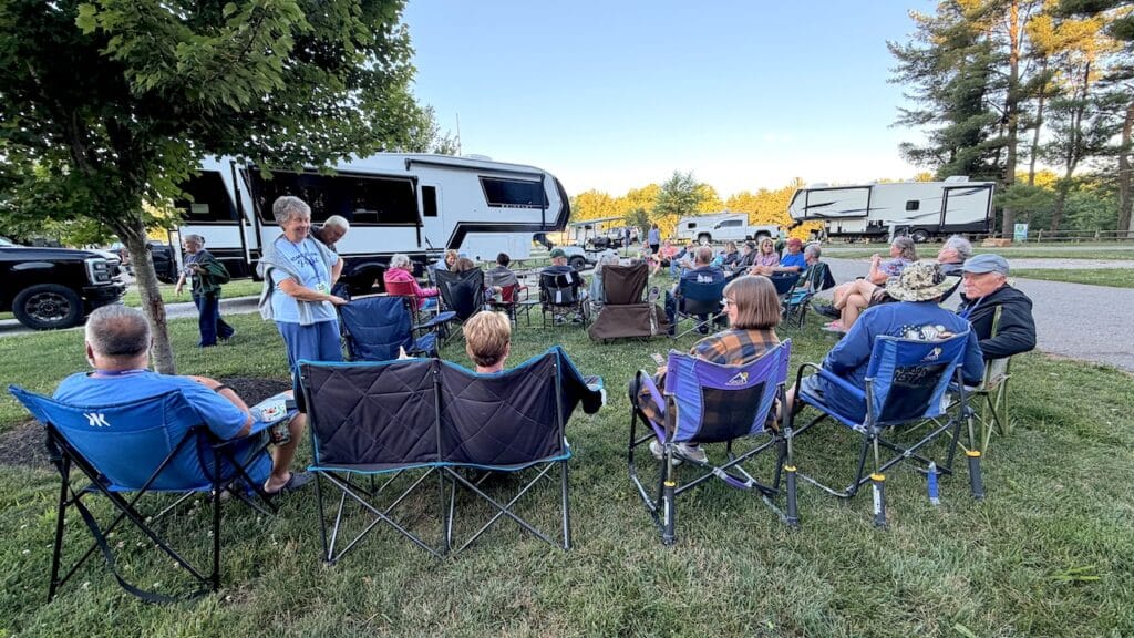 Retirement RV Travel Is Booming. Here's Why More Americans Are Hitting the Road 5 photo of seniors gathered around an rav prk campfire
